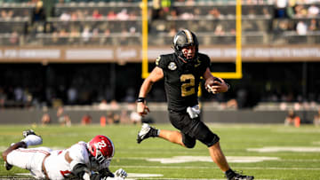 Oct 5, 2024; Nashville, Tennessee, USA;  Vanderbilt Commodores quarterback Diego Pavia (2) breaks the tackle of Alabama Crimson Tide defensive lineman LT Overton (22) during the first half at FirstBank Stadium. Mandatory Credit: Steve Roberts-Imagn Images