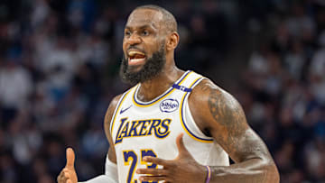 Los Angeles Lakers forward LeBron James talks with his coach during a stoppage against the Minnesota Timberwolves.