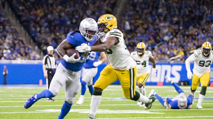 Jan 9, 2022; Detroit, Michigan, USA; Detroit Lions running back Jamaal Williams (30) runs the ball against Green Bay Packers linebacker Jonathan Garvin (53) during the fourth quarter at Ford Field. Mandatory Credit: Raj Mehta-USA TODAY Sports