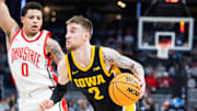 Mar 12, 2025; Indianapolis, IN, USA; Iowa Hawkeyes guard Brock Harding (2) dribbles the ball while Ohio State Buckeyes guard John Mobley Jr. (0) defends in the first half  at Gainbridge Fieldhouse. Mandatory Credit: Trevor Ruszkowski-Imagn Images