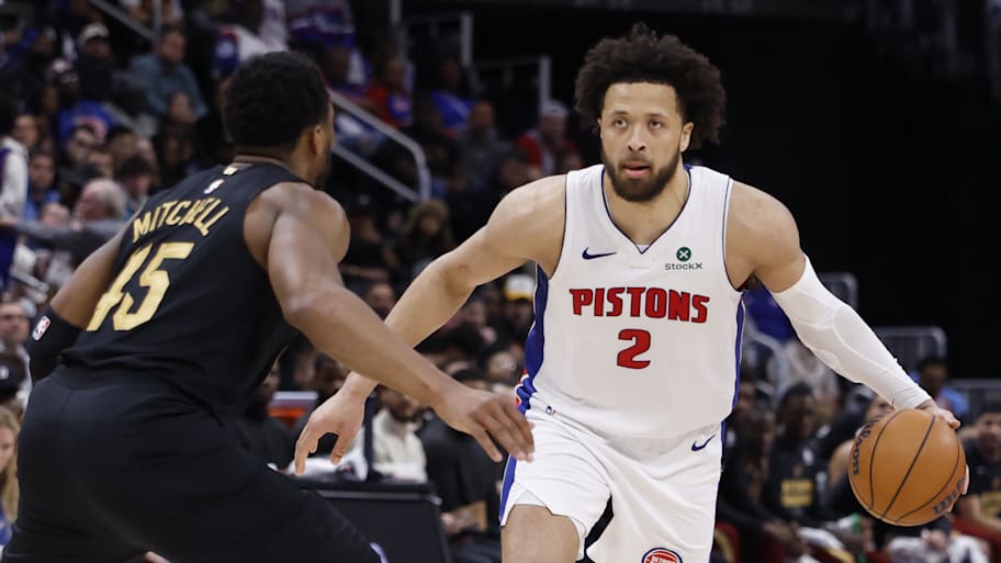 Pistons guard Cade Cunningham dribbles defended by Cavaliers guard Donovan Mitchell.
