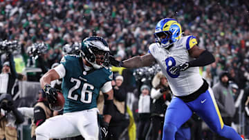Jan 19, 2025; Philadelphia, Pennsylvania, USA; Philadelphia Eagles running back Saquon Barkley (26) scores a touchdown past Los Angeles Rams linebacker Jared Verse (8) in the first half in a 2025 NFC divisional round game at Lincoln Financial Field. Mandatory Credit: Bill Streicher-Imagn Images