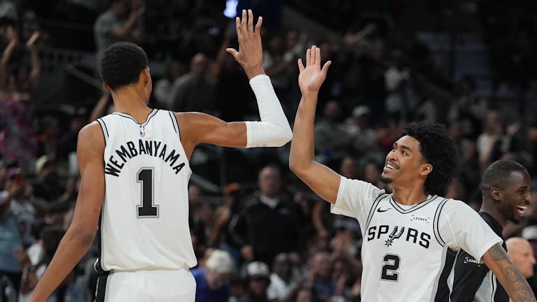 Oct 26, 2025; San Antonio, Texas, USA; San Antonio Spurs forward Victor Wembanyama (1) and guard Dylan Harper (2) celebrates in the second half against the Brooklyn Nets at Frost Bank Center.