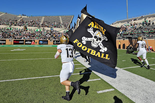 Daily leads his teammates on to the field with the black flag before a game this season.