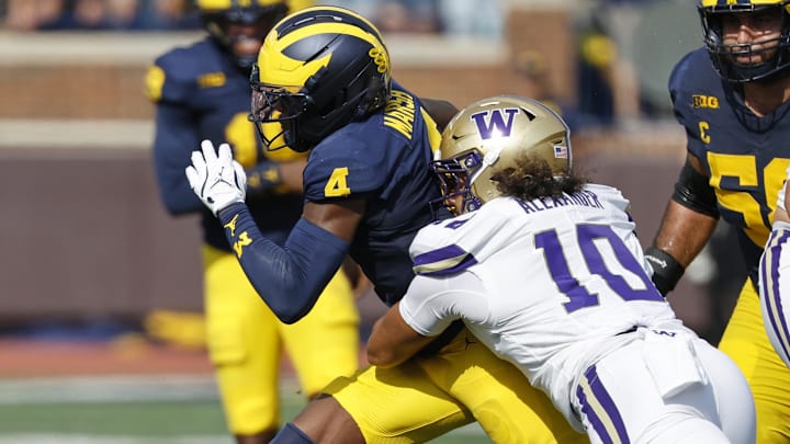 Oct 18, 2025; Ann Arbor, Michigan, USA;  Michigan Wolverines wide receiver Andrew Marsh (4) is tackled by Washington Huskies linebacker Xe'Ree Alexander (10) in the first half at Michigan Stadium. Mandatory Credit: Rick Osentoski-Imagn Images