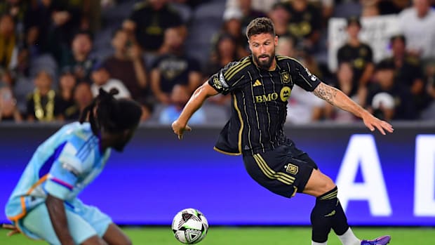 Olivier Giroud dribbles the ball past a defender.