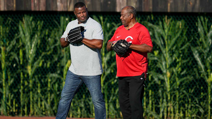 Hall of Fame baseball player and former Cincinnati Reds center fielder Ken Griffey Jr., left, asks his dad and fellow  Hall of Fame player Ken Griffey Sr., if he  d like to play catch  before a baseball game between the Chicago Cubs and the Cincinnati Reds, Thursday, Aug. 11, 2022, at the MLB Field of Dreams stadium in Dyersville, Iowa