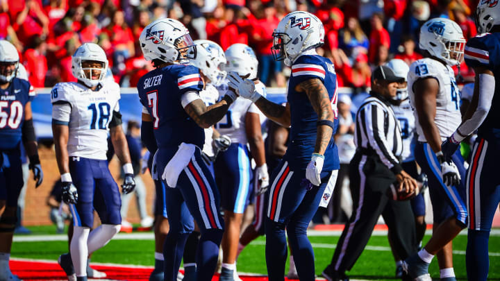 Nov 11, 2023; Lynchburg, Virginia, USA;  Liberty Flames quarterback Kaidon Salter (7) celebrates a touchdown run with Liberty Flames wide receiver CJ Daniels (4) during the second quarter at Williams Stadium. Mandatory Credit: Brian Bishop-USA TODAY Sports