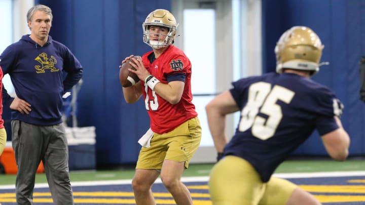 Notre Dame quarterback Riley Leonard (13) passes to Jack Larsen (85) as quarterbacks coach Gino Guidugli looks on at Notre Dame spring football practice Thursday, March 7, 2024, at the Irish Athletics Center in South Bend.