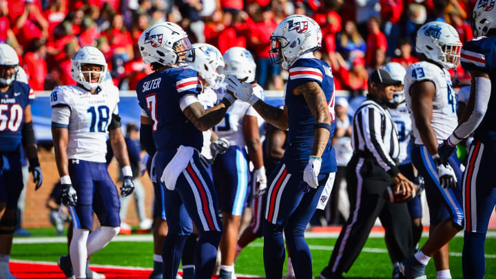 Nov 11, 2023; Lynchburg, Virginia, USA;  Liberty Flames quarterback Kaidon Salter (7) celebrates a touchdown run with Liberty Flames wide receiver CJ Daniels (4) during the second quarter at Williams Stadium. Mandatory Credit: Brian Bishop-USA TODAY Sports