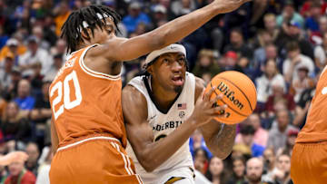 Vanderbilt Commodores guard MJ Collins Jr. (2) goes under the arm of Texas Longhorns guard Tre Johnson (20) during the first half at Bridgestone Arena. 