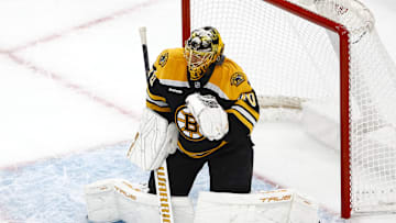 Dec 21, 2024; Boston, Massachusetts, USA; Boston Bruins goaltender Joonas Korpisalo (70) fights off a shot by his mask during the second period against the Buffalo Sabres at TD Garden. Mandatory Credit: Winslow Townson-Imagn Images