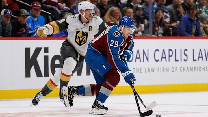 Nov 27, 2024; Denver, Colorado, USA; Colorado Avalanche center Nathan MacKinnon (29) controls the puck ahead of Vegas Golden Knights center Jack Eichel (9) in the third period at Ball Arena. Mandatory Credit: Isaiah J. Downing-Imagn Images
