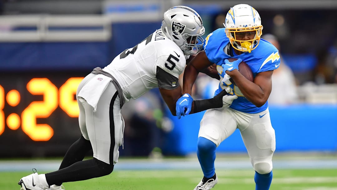 Oct 1, 2023; Inglewood, California, USA; Los Angeles Chargers running back Joshua Kelley (25) runs the ball against Las Vegas Raiders linebacker Divine Deablo (5) during the first half at SoFi Stadium. Mandatory Credit: Gary A. Vasquez-Imagn Images