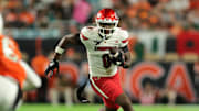 Oct 17, 2025; Miami Gardens, Florida, USA; Louisville Cardinals wide receiver Chris Bell (0) carries the football against the Miami Hurricanes during the first quarter at Hard Rock Stadium. Mandatory Credit: Sam Navarro-Imagn Images