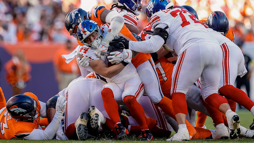 Oct 19, 2025; Denver, Colorado, USA; New York Giants running back Cam Skattebo (44) is tackled by Denver Broncos defensive end John Franklin-Myers (98) as guard Jermaine Eluemunor (72) defends in the fourth quarter at Empower Field at Mile High. Mandatory Credit: Isaiah J. Downing-Imagn Images
