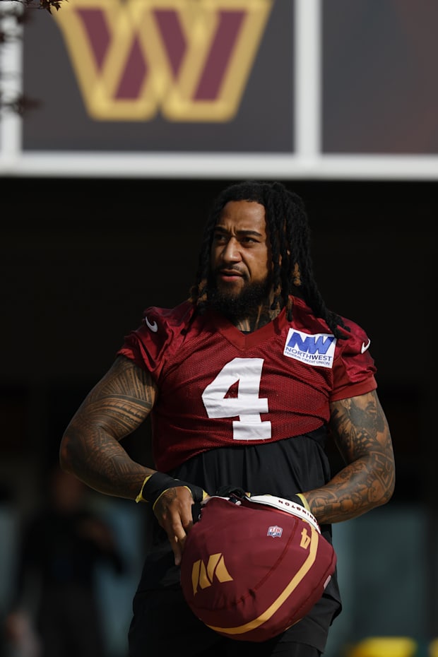 Washington Commanders linebacker Frankie Luvu walks out of team headquarters onto the fields