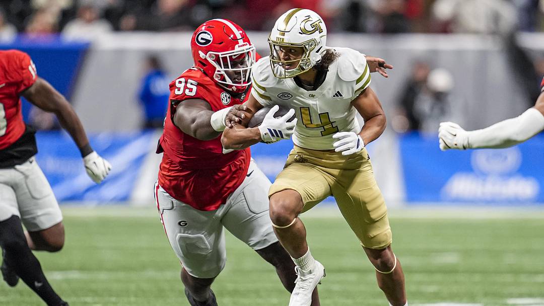 Nov 28, 2025; Atlanta, Georgia, USA; Georgia Tech Yellow Jackets wide receiver Isiah Canion (4) runs against Georgia Bulldogs defensive lineman Nnamdi Ogboko (95) during the second half at Mercedes-Benz Stadium. Mandatory Credit: Dale Zanine-Imagn Images