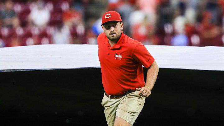 Aug 12, 2025; Cincinnati, Ohio, USA; A member of the grounds crew pulls the tarp over the field during a rain delay in the seventh inning in the game between the Philadelphia Phillies and the Cincinnati Reds at Great American Ball Park. Mandatory Credit: Katie Stratman-Imagn Images