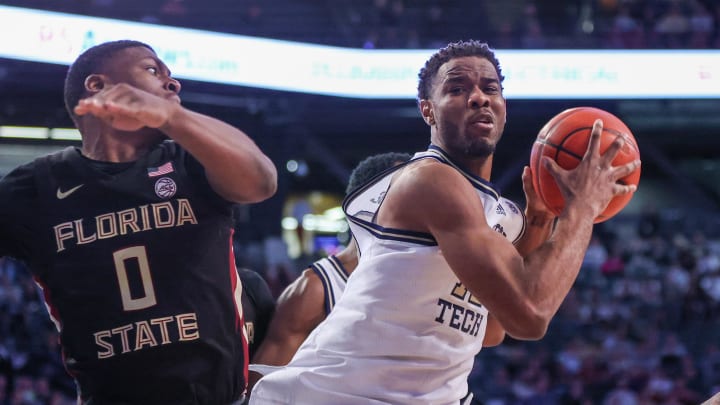 Mar 2, 2024; Atlanta, Georgia, USA; Georgia Tech Yellow Jackets forward Tyzhaun Claude (12) grabs a rebound past Florida State Seminoles guard Chandler Jackson (0) in the second half at McCamish Pavilion. Mandatory Credit: Brett Davis-USA TODAY Sports