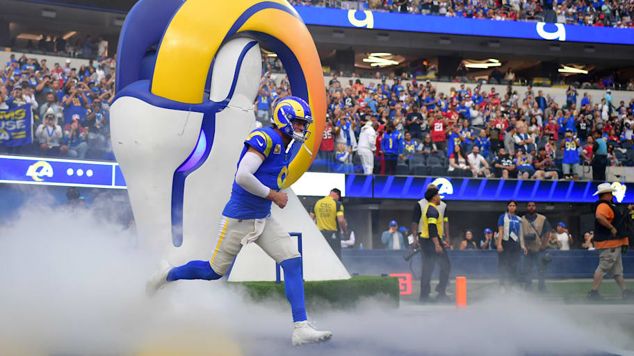 Matthew Stafford runs onto the field through smoke.