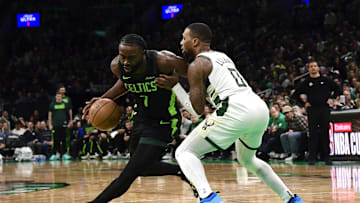 Dec 6, 2024; Boston, Massachusetts, USA;  Boston Celtics guard Jaylen Brown (7) controls the ball while Milwaukee Bucks guard Damian Lillard (0) defends during the second half at TD Garden. Mandatory Credit: Bob DeChiara-Imagn Images