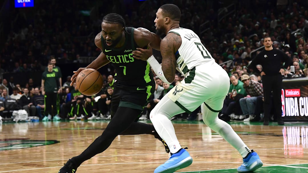 Dec 6, 2024; Boston, Massachusetts, USA;  Boston Celtics guard Jaylen Brown (7) controls the ball while Milwaukee Bucks guard Damian Lillard (0) defends during the second half at TD Garden. Mandatory Credit: Bob DeChiara-Imagn Images