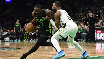 Dec 6, 2024; Boston, Massachusetts, USA;  Boston Celtics guard Jaylen Brown (7) controls the ball while Milwaukee Bucks guard Damian Lillard (0) defends during the second half at TD Garden. Mandatory Credit: Bob DeChiara-Imagn Images