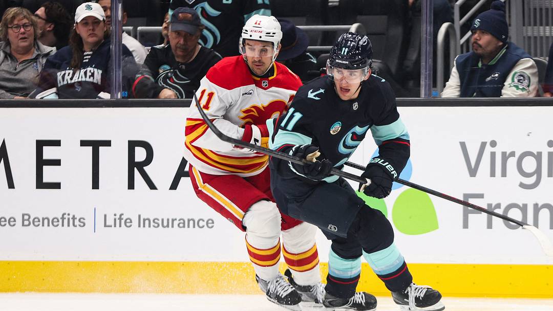 Oct 4, 2026; Seattle, Washington, USA; Seattle Kraken right wing Mackie Samoskevich (11) and Calgary Flames center Mikael Backlund (11) battle for the puck in the second period at Climate Pledge Arena. Mandatory Credit: Kevin Ng-Imagn Images