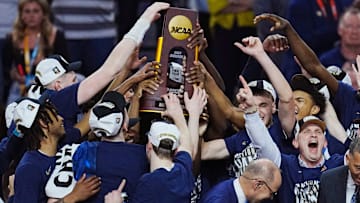 Connecticut Huskies head coach Dan Hurley and players celebrate with the trophy after defeating the Purdue Boilermakers in the national championship game of the Final Four of the 2024 NCAA Tournament at State Farm Stadium in Glendale on April 8, 2024.
