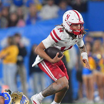 Nebraska quarterback TJ Lateef runs past UCLA Bruins defensive lineman Jacob Busic at Rose Bowl.