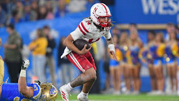 Nov 8, 2025; Pasadena, California, USA; Nebraska Cornhuskers quarterback TJ Lateef (14) runs the ball ahead of UCLA Bruins defensive lineman Jacob Busic (97) during the second half at the Rose Bowl. Mandatory Credit: Gary A. Vasquez-Imagn Images