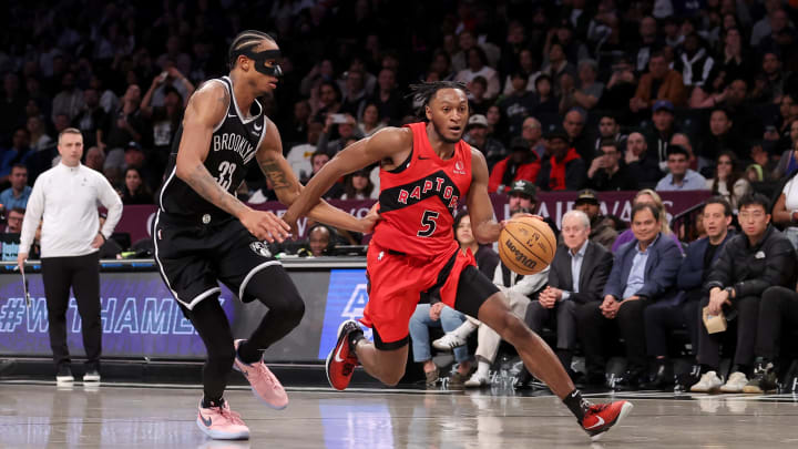 Apr 10, 2024; Brooklyn, New York, USA; Toronto Raptors guard Immanuel Quickley (5) drives to the basket against Brooklyn Nets center Nic Claxton (33) during the fourth quarter at Barclays Center. Mandatory Credit: Brad Penner-USA TODAY Sports