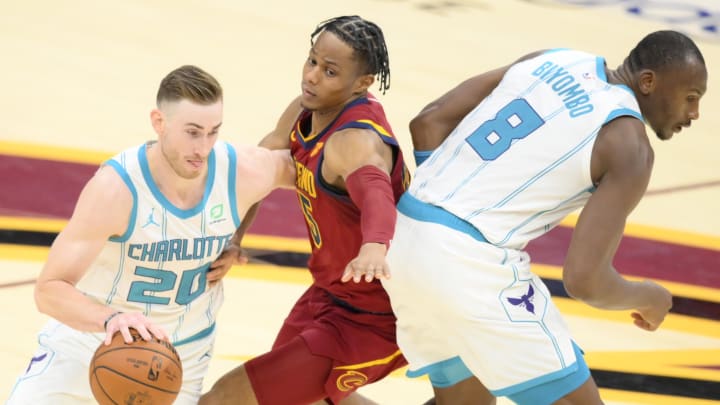 Dec 23, 2020; Cleveland, Ohio, USA; Charlotte Hornets forward Gordon Hayward (20) moves the ball past center Bismack Biyombo (8) and Cleveland Cavaliers guard Isaac Okoro (35) in the second quarter at Rocket Mortgage FieldHouse. Mandatory Credit: David Richard-USA TODAY Sports