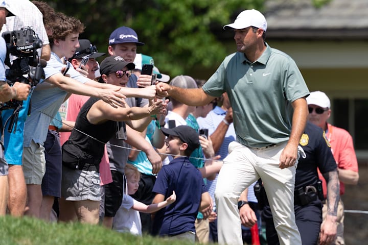 Scottie Scheffler fist bumps fans on his way to the first tee during the third round of the Travelers Championship