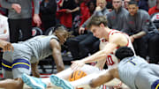 Mar 4, 2025; Salt Lake City, Utah, USA; Utah Utes forward Jake Wahlin (10) goes to the floor for a loose ball with West Virginia Mountaineers guard Javon Small (left) and guard Joseph Yesufu (1) during the second half at Jon M. Huntsman Center. Mandatory Credit: Rob Gray-Imagn Images