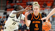 Oklahoma State guard Anna Gret Asi (4) drives to the basket as Colorado forward Nyamer Diew (11) defends during the college basketball game between the Oklahoma State University Cowgirls and the Colorado Buffaloes, Saturday, Feb., 22, 2025.