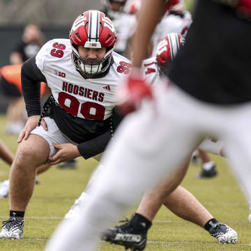 Defensive tackle James Carpenter stretches during an Indiana football practice on April 9, 2024.