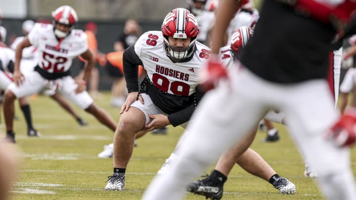 Defensive tackle James Carpenter stretches during an Indiana football practice on April 9, 2024.