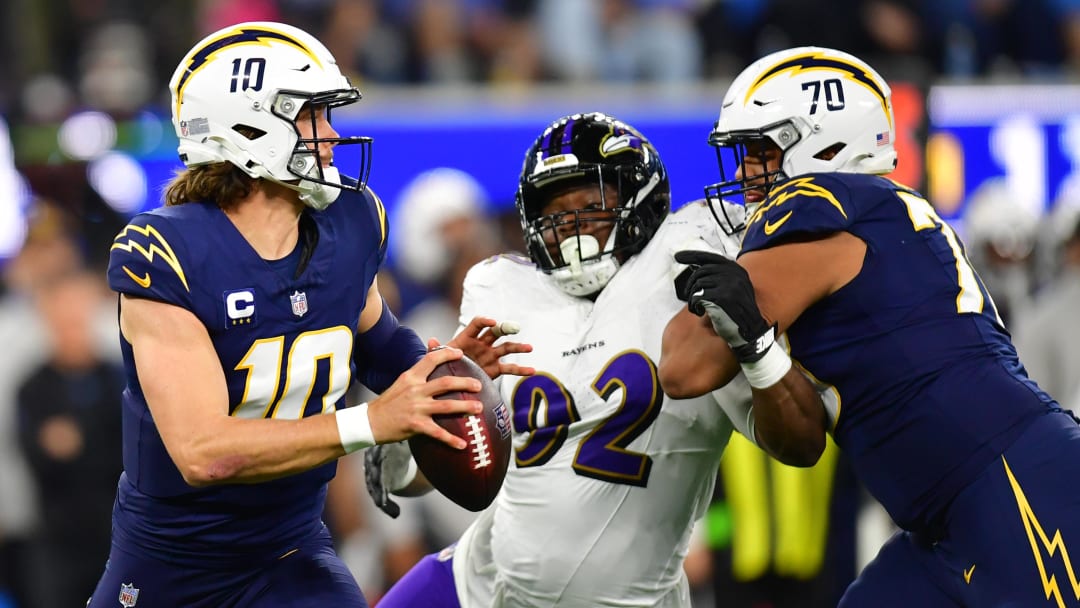 Nov 26, 2023; Inglewood, California, USA; Los Angeles Chargers quarterback Justin Herbert (10) drops back to pass as offensive tackle Rashawn Slater (70) provides coverage against Baltimore Ravens defensive tackle Justin Madubuike (92) during the first half at SoFi Stadium. Mandatory Credit: Gary A. Vasquez-USA TODAY Sports