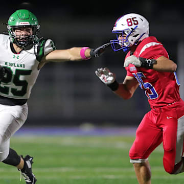 Highland running back Casey Myser, left, picks up yards against Revere defensive end Michael Mark during the first half of a high school football game, Oct. 17, 2025, in Bath Township, Ohio.