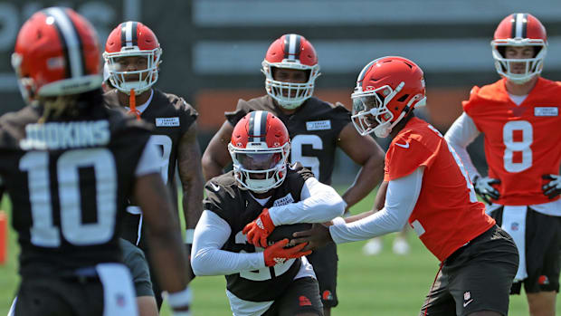 Cleveland Browns running back Dylan Sampson (22) takes a handoff from quarterback Shedeur Sanders (12) during practice at NFL