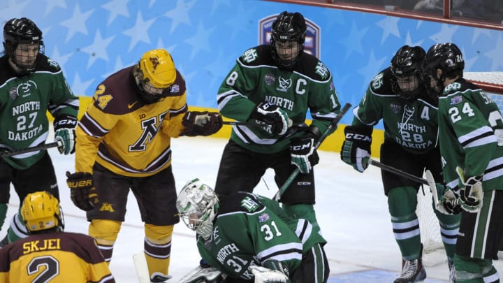 Apr 10, 2014; Philadelphia, PA, USA; North Dakota Sioux goaltender Zane Gothberg (31) holds onto the puck against Minnesota Gophers forward Hudson Fasching (24) (24) during the second period in the semifinals of the Frozen Four college ice hockey tournament at Wells Fargo Center. Mandatory Credit: Eric Hartline-USA TODAY Sports