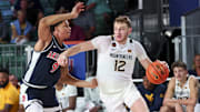 Nov 29, 2024; Paradise Island, Bahamas, BHS;  West Virginia Mountaineers guard Tucker DeVries (12) drives to the basket as Arizona Wildcats forward Carter Bryant (9) defends during the second half at Imperial Arena at the Atlantis resort.  Mandatory Credit: Kevin Jairaj-Imagn Images