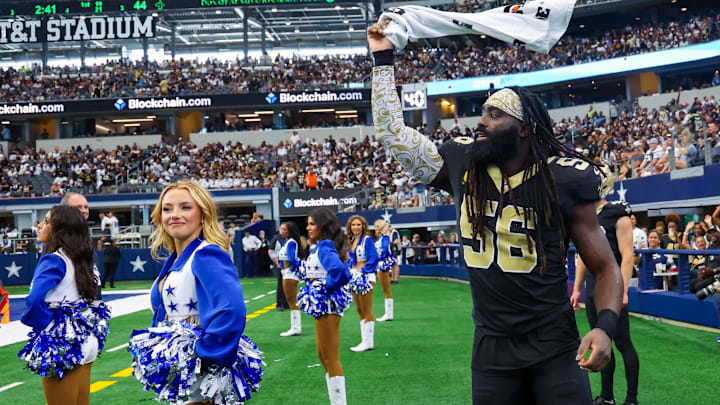 Sep 15, 2024; Arlington, Texas, USA;  New Orleans Saints linebacker Demario Davis (56) waves a towel in front of a Dallas Cowboys cheerleader during the fourth quarter at AT&T Stadium. 