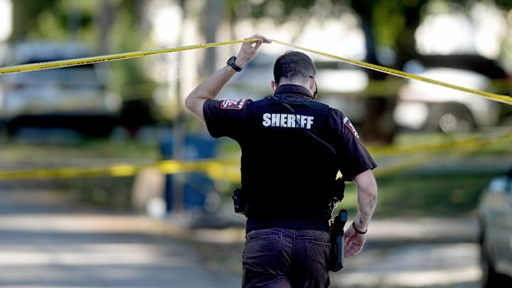 A Sangamon County Sheriff's deputy walks under police tape at the scene of a shooting in the 3000 block of Hoover Avenue on October 9, 2025.