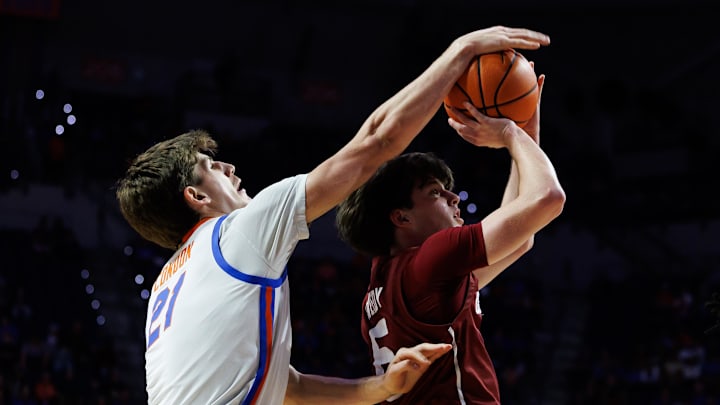 Dec 21, 2025; Gainesville, Florida, USA; Florida Gators forward Alex Condon (21) blocks a shot from Colgate Raiders guard Ben Tweedy (6) during the first half at Exactech Arena at the Stephen C. O'Connell Center. Mandatory Credit: Matt Pendleton-Imagn Images