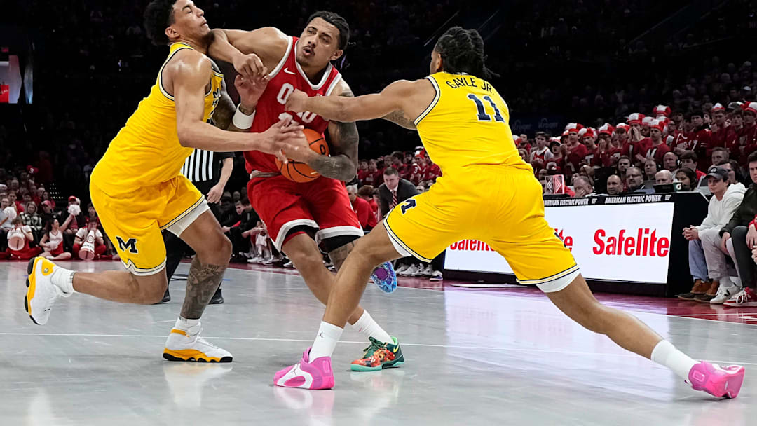 Ohio State Buckeyes forward Devin Royal (21) collides with Michigan Wolverines forward Yaxel Lendeborg (23) and guard Roddy Gayle Jr. (11) during the first half of the NCAA men's basketball game at the Schottenstein Center in Columbus on Feb. 8, 2026.