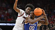 Nov 11, 2025; Louisville, Kentucky, USA;  Kentucky Wildcats guard Otega Oweh (00) drives to the basket against Louisville Cardinals guard Adrian Wooley (14) during the first half at KFC Yum! Center. Mandatory Credit: Jamie Rhodes-Imagn Images