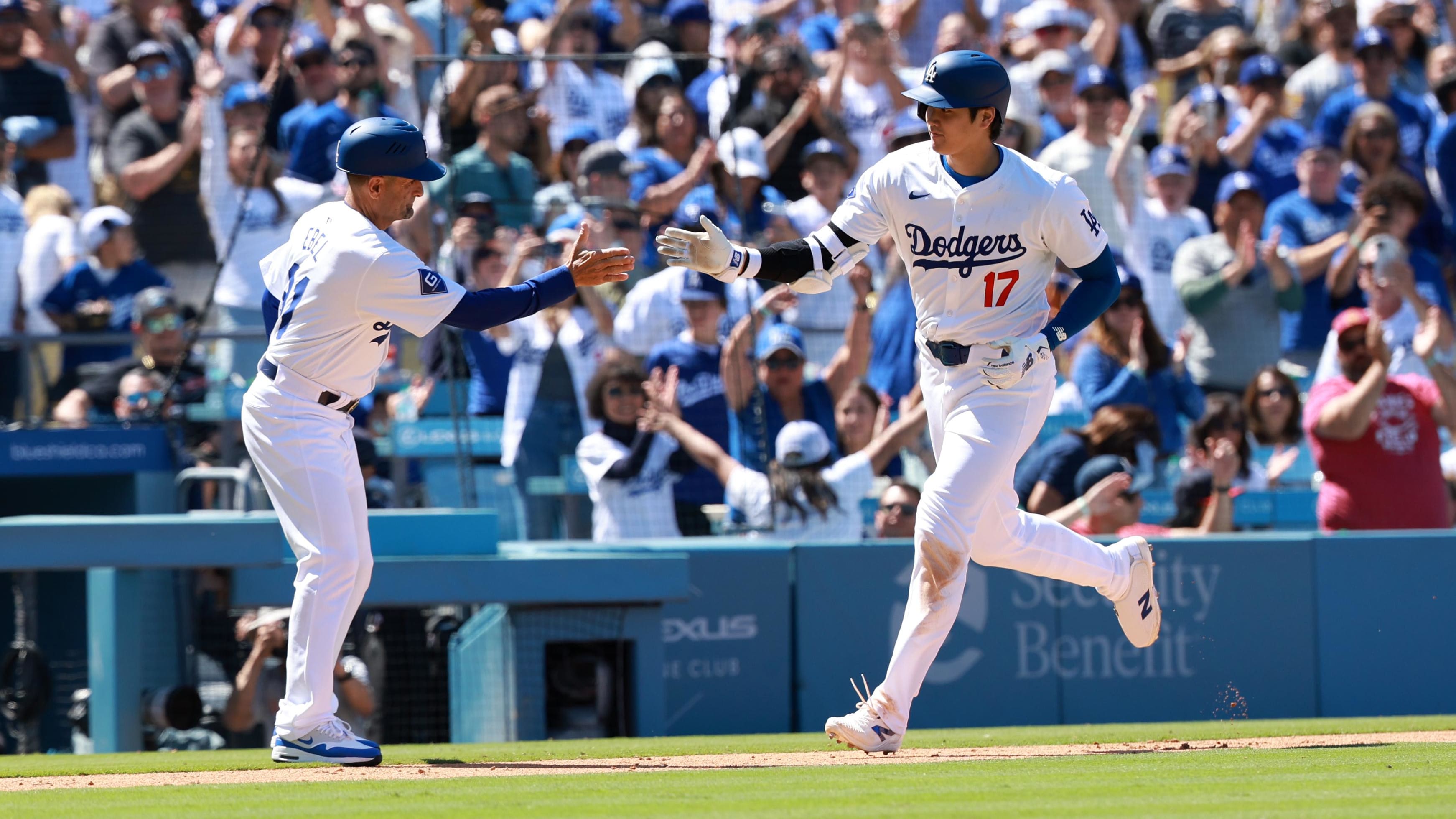 Shohei Ohtani high-fives the Dodgers' third base coach